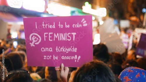 Translation: Its hard in Turkey. Feminist walk city night. 8 march feminism protest. Many demonstration banners. Woman riot anti violence. Female rights picket. Girl power. People hold strike placards photo