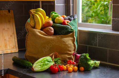 shopping bag with vegetables and fruits in kitchen table, healthy food background.
