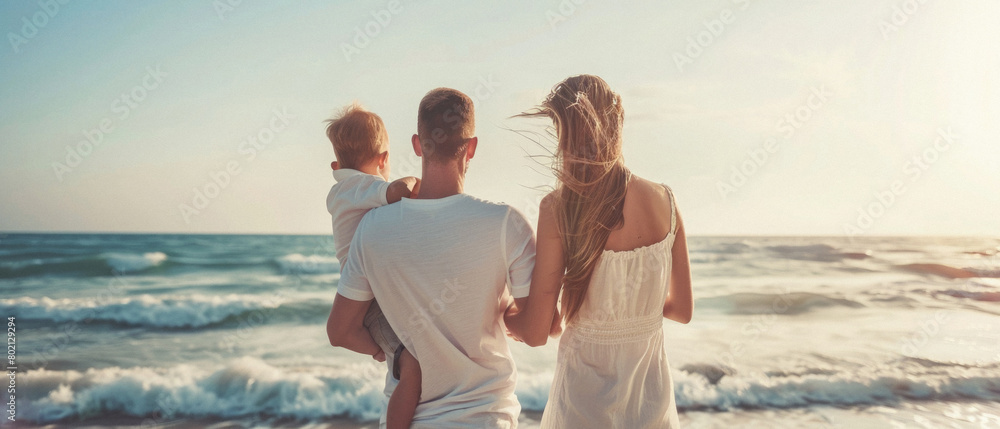 Fototapeta premium A family of three, a man and two children, are standing on the beach