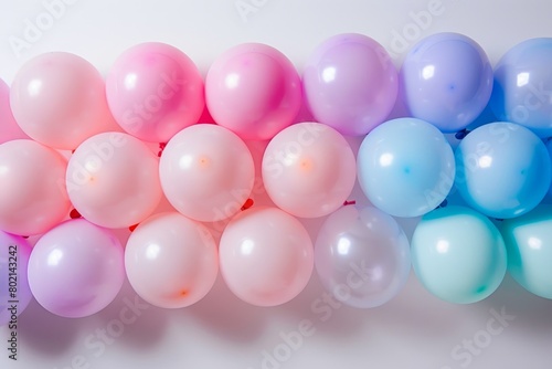 A row of pastel-colored balloons arranged in a gradient pattern against a white backdrop