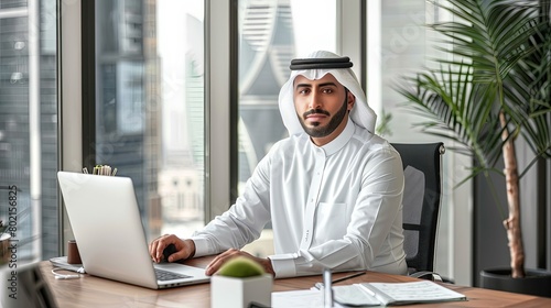 Stunning visual of a Middle Eastern manager at work, sitting at a stylish desk in a creative office space, showcasing leadership and elegance.