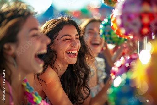 A lively group of young women laughs joyfully while holding colorful balloons, creating a vibrant and cheerful atmosphere