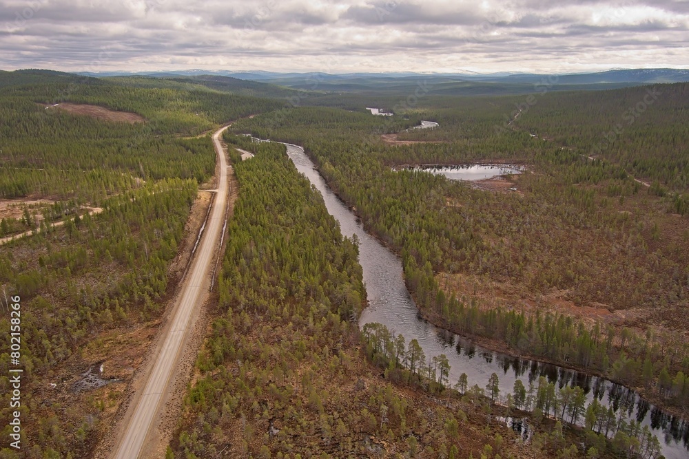 Aerial view of Rajajoosepintie road and Luttojoki river in cloudy spring weather, Lapland, Finland.