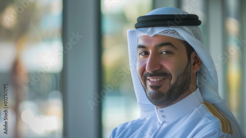 Happy Emirati Arab at office wearing Kandura looking at front ideal for Middle East business concept © Emil