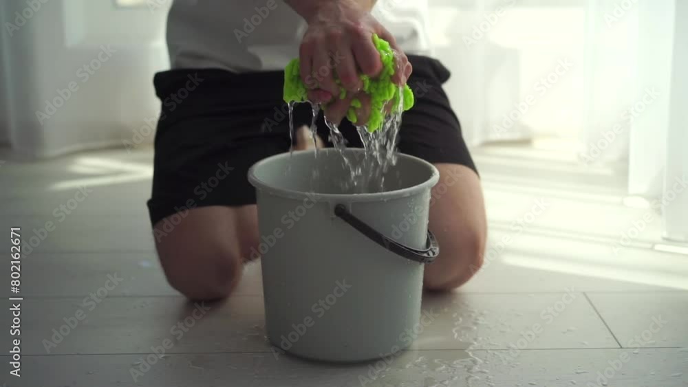 Twisting a floor cloth in a bucket of water Twisting a floor cloth in a bucket of water