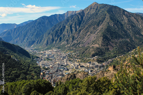 The city is surrounded by mountains against a background of blue sky from a bird's eye view, Andorra. photo