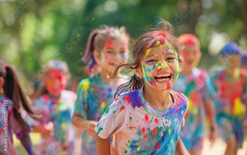 A group of children were running in the park  smiling and covered with colorful paint on their faces during an outdoor holi race