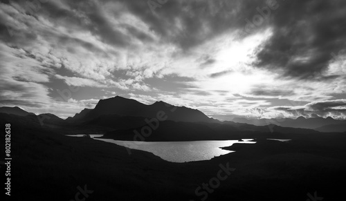 A black and white image of the views of the summit of Beinn Airigh Charr in the distance and Aird Mhor closer to the camera with Loch Kernsary in the foreground. photo