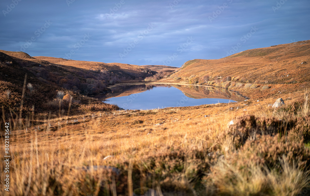 The small loch of Loch na h-Innse Gairbhe on the walking route to Slaggan Bay that runs along the stream of Allt Udrigill and starts from Achgarve near Gruinard Bay in the Scottish Highlands.