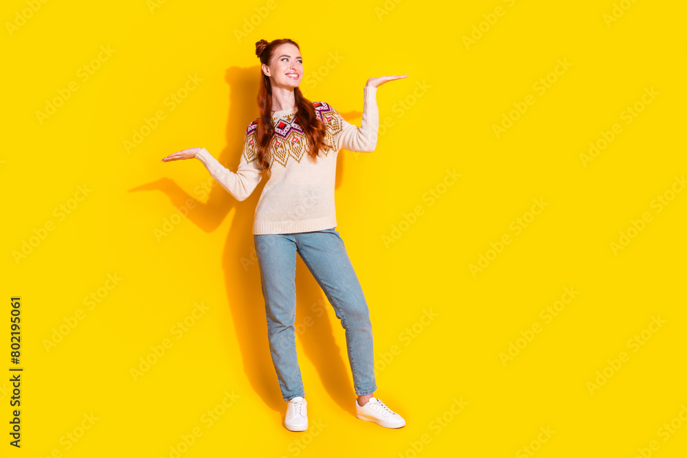 Photo portrait of attractive young woman compare look empty space dressed stylish knitted warm outfit isolated on yellow color background Photo portrait of attractive young woman compare look empty space dressed stylish knitted warm outfit isolated on yellow color background