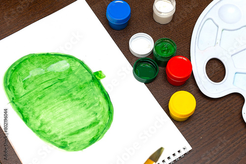 A child draws leafs on a tree. Ideas for drawing with finger paints. Finger painting for kids on white background. Little girl painting by finger hand paint color. Children development concept
