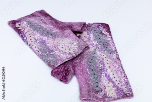 Close-up of purple knitted mittens on white background.