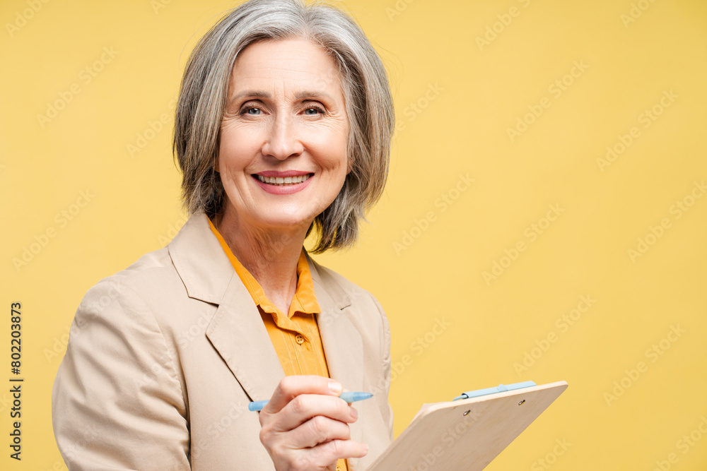 Portrait of smiling senior woman writing notes and dreaming isolated Portrait of smiling senior woman writing notes and dreaming isolated