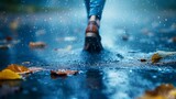 person walking o a wet road with puddles in autumn. 
