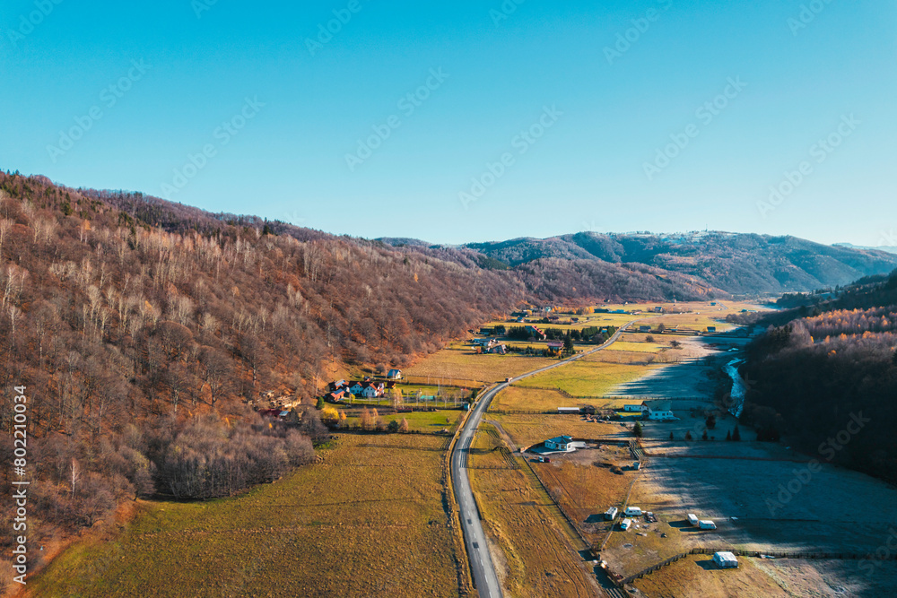 Fototapeta premium A breathtaking aerial view captures a tranquil rural landscape with a towering mountain in the background