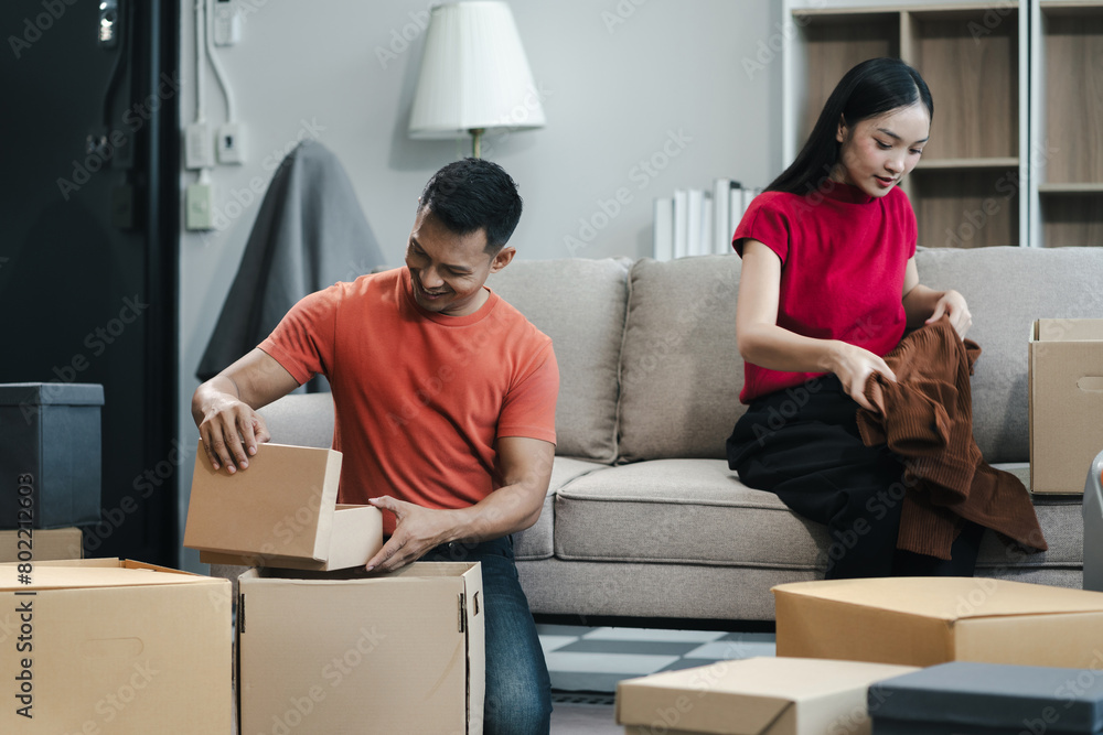 young couple helps put things in boxes and prepares to move to a new house. young couple helps put things in boxes and prepares to move to a new house.