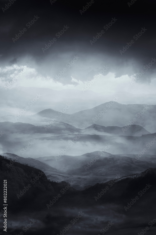 mysterious dark landscape with hills and mountains shrouded in fog mysterious dark landscape with hills and mountains shrouded in fog