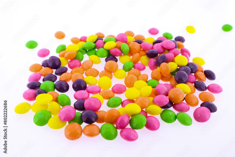 Multi-colored candies scattered on a white background Multi-colored candies scattered on a white background