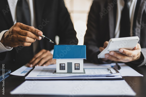 Businessman are meeting to discuss the returns of real estate investments. Real estate investment concepts, cash flow, rent, mortgages, house and land appraisals. © Wasan