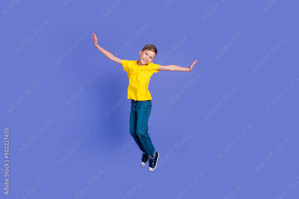 Full length photo of cheerful optimistic boy wear stylish clothes fly air good mood isolated on violet color background Full length photo of cheerful optimistic boy wear stylish clothes fly air good mood isolated on violet color background
