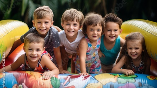 Excited children having a great time playing and bouncing on the inflatable bounce house photo