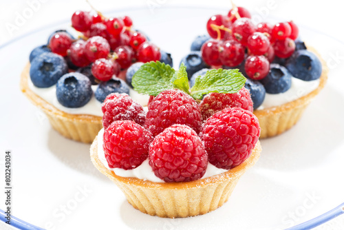 mini cakes with cream and berries, closeup © cook_inspire