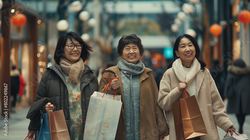 Group of elderly women holding shopping bags cheerfully in the city at night Happy trading photo