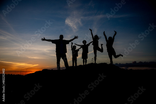 silhouette of a family with raised hands photo