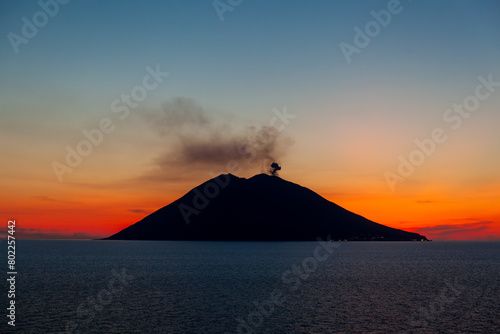 De vulkaan Stromboli stoot rookwolken uit en is de meest actieve vulkaan van Europa. Stromboli is continu actief en spuwt meerdere keren per uur lava omhoog. Bij ondergaande zon. photo