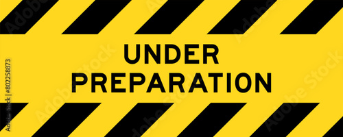 Yellow and black color with line striped label banner with word under preparation