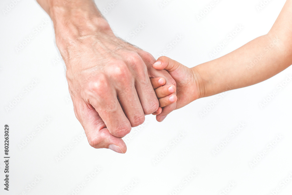 child holding dad's finger, close-up, face not visible, concept of fatherhood and father's day child holding dad's finger, close-up, face not visible, concept of fatherhood and father's day