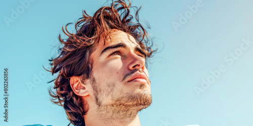 Young Man with Windblown Hair Under Blue Sky photo