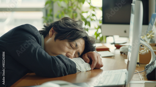 オフィスで仕事に疲れて寝てるビジネスマン