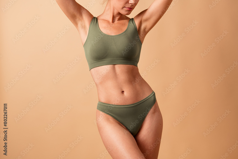 © deagreez - Cropped no filter photo of adorable confident sporty woman with raised hands clean clear pure body isolated on beige color background