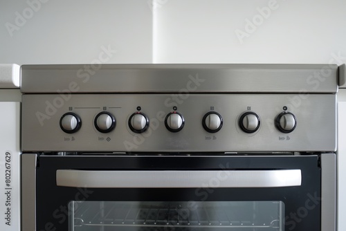 Close-up of a contemporary stainless steel oven with knobs