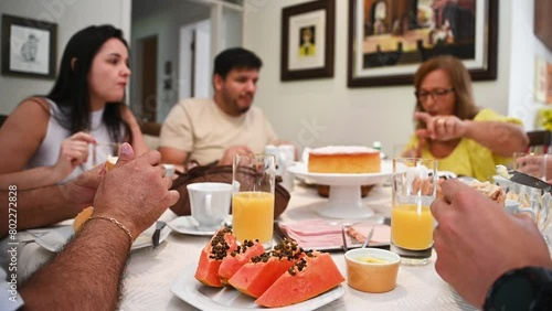 Família em casa sentada a mesa pra tomar café da manhã, reunião de família, família feliz comendo. Mesa de café da manha com frutas e pão photo