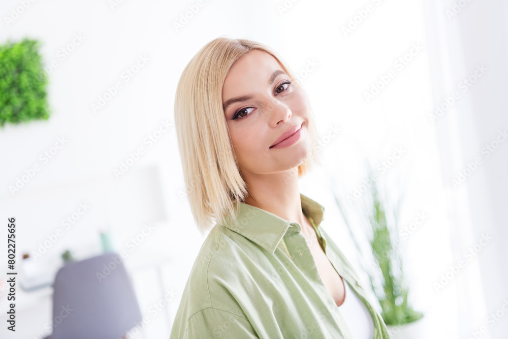 Portrait of young pretty cute woman blonde bob hair poses wearing khaki shirt in daylight at home with minimalism decorations indoors Portrait of young pretty cute woman blonde bob hair poses wearing khaki shirt in daylight at home with minimalism decorations indoors