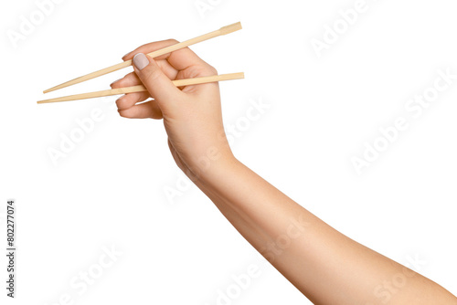 Картината върху платно A woman's hand holds wooden chopsticks for sushi or rolls on a blank background