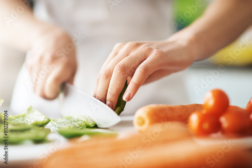 Cooking, hands and knife for vegetables on kitchen counter in home for diet, health or nutrition. Chef, food recipe and natural ingredients with person preparing organic meal for dinner or wellness