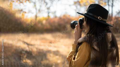 Woman photographer in a hat photographing autumn nature. Travel and hobby concept © mtrlin