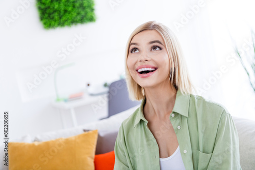 Portrait of young amazed housewife woman wear khaki shirt looking above at oclock timer she has a lot of time to make room cleaning