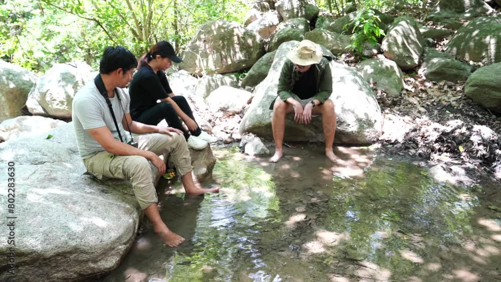 Group of three Asian friends, two men and one woman, have a good relationship,hiking, sitting and resting in the forest, summer time trip. Lifestyle concept Group of three Asian friends, two men and one woman, have a good relationship,hiking, sitting and resting in the forest, summer time trip. Lifestyle concept