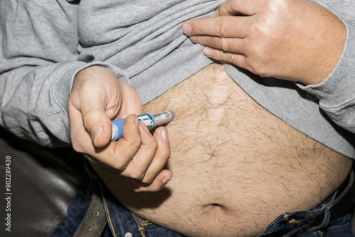 Diabetic man injects himself with Ozempic Insulin injection pen for diabetics.