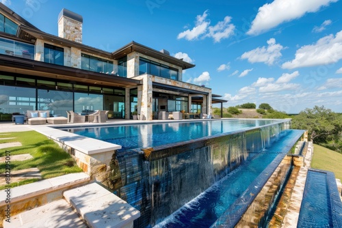 A large luxury home with a blue water pool and green grass areas.