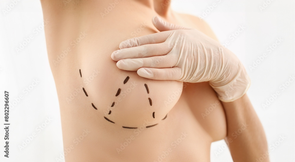 Female hand in gloves holding breast closeup on doctor mammology clinic reception. Mammary glands test biopsy implant silicone insert tumor human concept