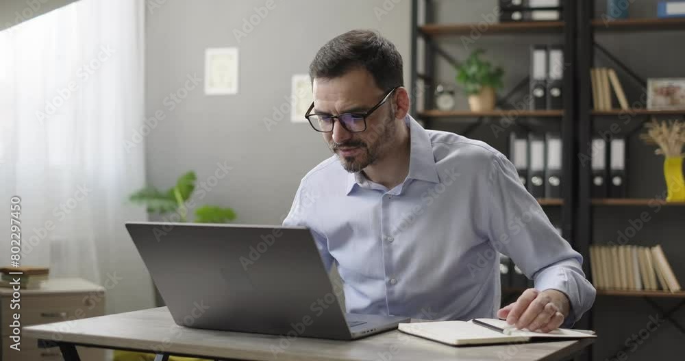 Smiling man using laptop computer, making notes at home office. Corporate training, virtual meeting, study with online tutor teacher, advanced adult learning course, remote study Smiling man using laptop computer, making notes at home office. Corporate training, virtual meeting, study with online tutor teacher, advanced adult learning course, remote study