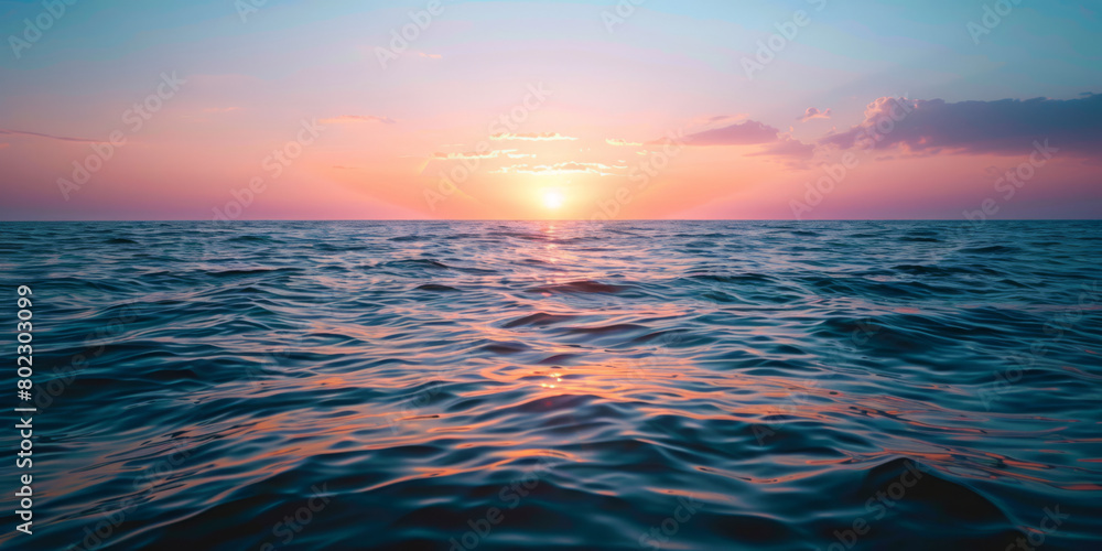 The ocean is calm and the sky is a beautiful pink color