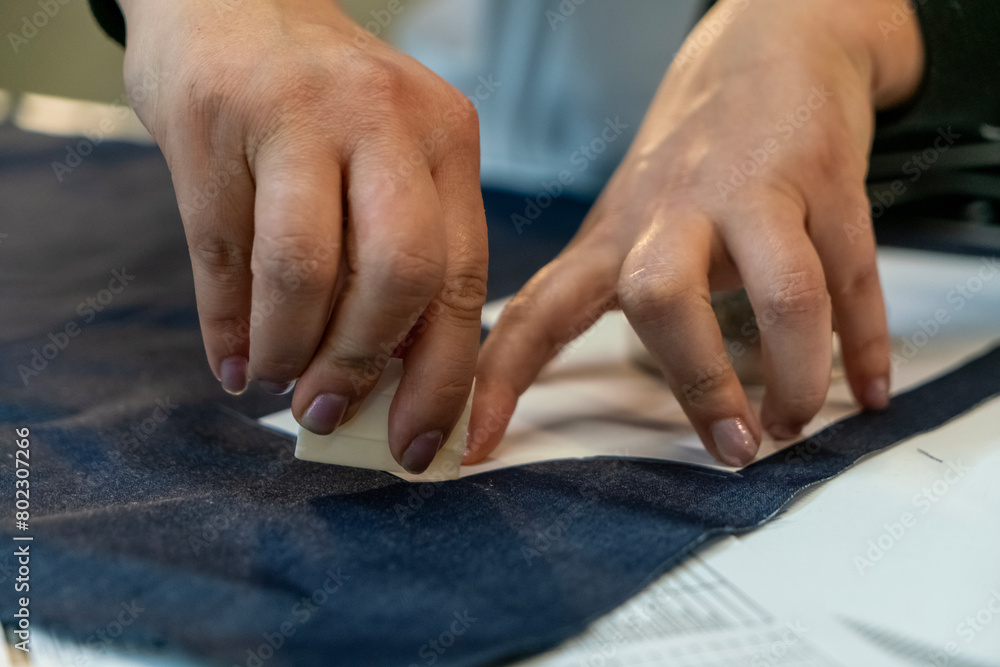 Close up view of tailor's hand marking sewing pattern on fabric with soap. Close up view of tailor's hand marking sewing pattern on fabric with soap.