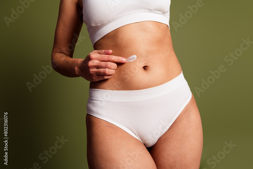 No retouch cropped photo of lady tummy underwear lingerie tacking care pimple skin isolated green color background © deagreez