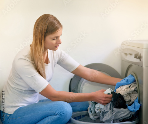 Woman, laundry and washing machine for cleaning in home, dirty clothes and routine housework. Female person, linen and fabric maintenance in apartment, sanitary and maid for hygiene housekeeping